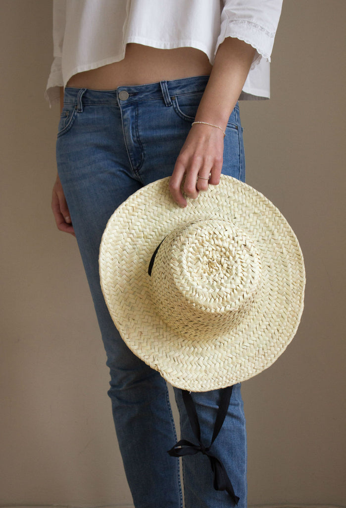 Model in jeans wearing a palm leaf hat by Sabellar